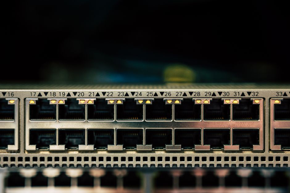 Vista detallada de un switch de red con múltiples puertos ethernet e indicadores LED.